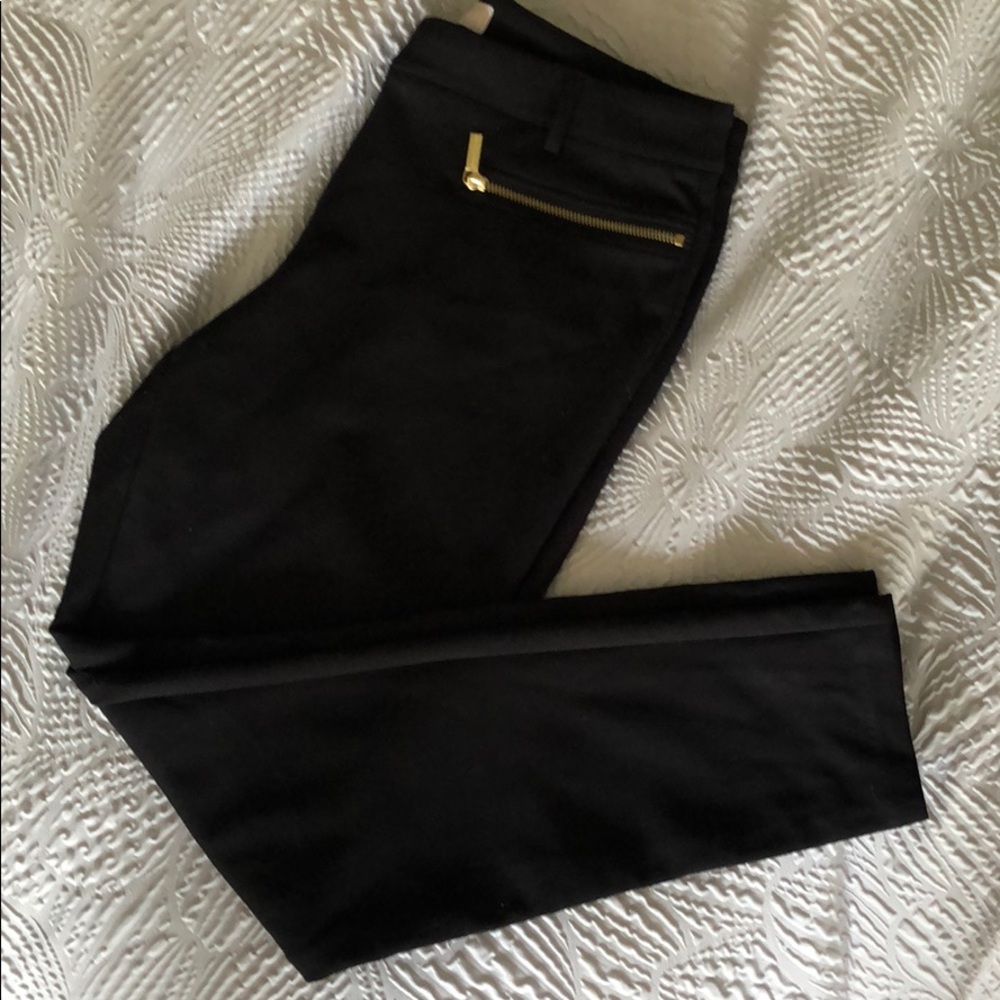Black pointe knit pants with gold accents.